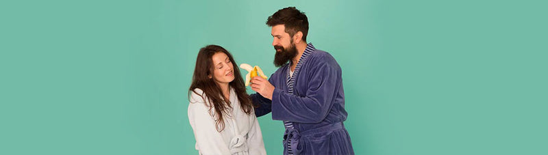 a man holding a banana to a woman